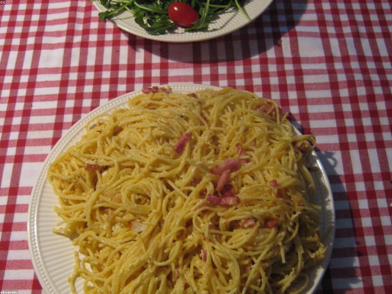 A bowl of creamy carbonara pasta with crispy pancetta bits and fresh black pepper