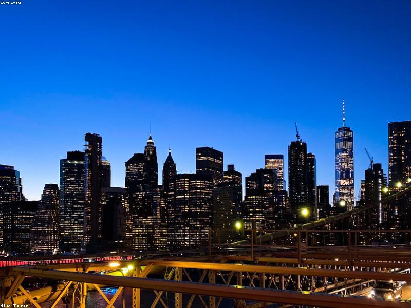 Couple walking on Brooklyn Bridge with city skyline in background